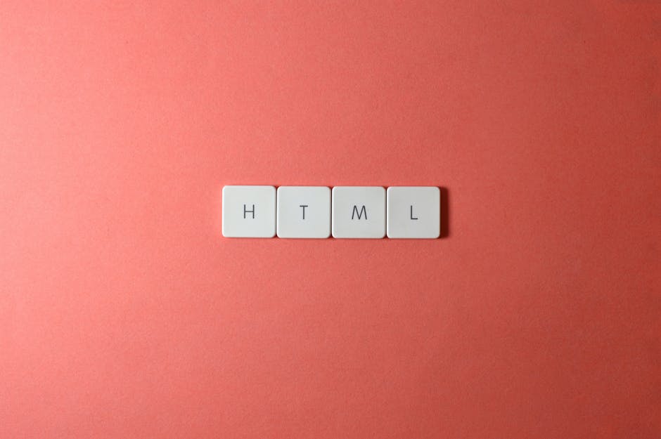 A close-up view of four white rectangular tiles arranged in a row on a soft pink background. Each tile features a black letter spelling out 'HTML', with the first letter 'H' on the left, followed by '